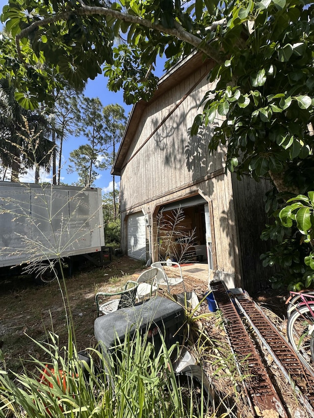 view of property exterior featuring an outdoor structure, a garage, and a barn