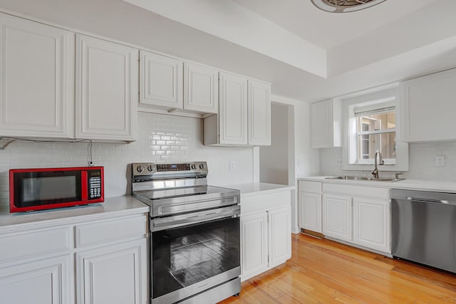 9109 SE Riverfront Ter Unit B, Jupiter, FL 33469 - kitchen featuring stainless steel appliances, a sink, tasteful backsplash, light countertops, and white cabinets