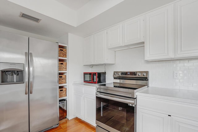 9109 SE Riverfront Ter Unit B, Jupiter, FL 33469 - kitchen with appliances with stainless steel finishes, light countertops, tasteful backsplash, and white cabinetry