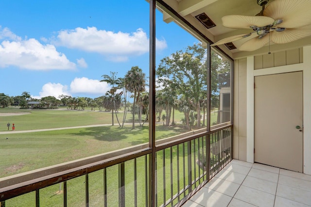 unfurnished sunroom with a ceiling fan and view of golf course