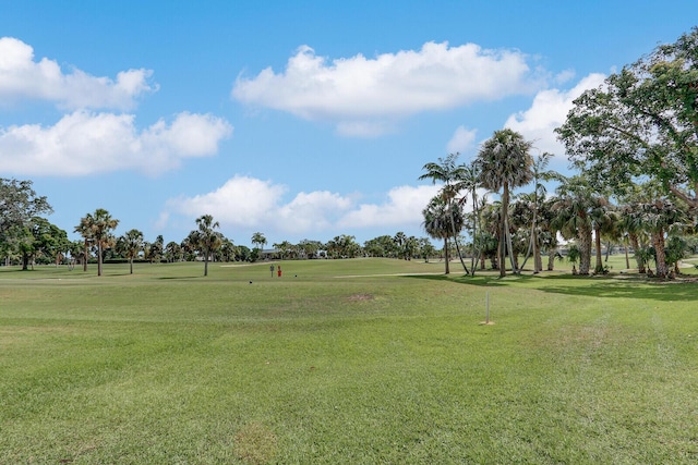 view of community featuring golf course view and a yard