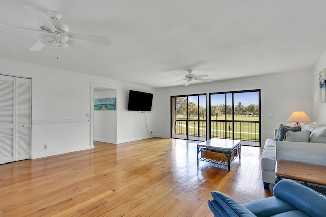 living area with ceiling fan, light wood-type flooring, and baseboards