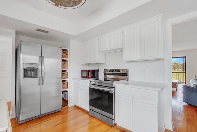 kitchen featuring stainless steel appliances, light wood-style flooring, light countertops, and white cabinets