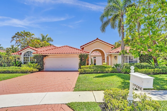 19262 Redberry Ct, Boca Raton, FL 33498 - mediterranean / spanish-style home with stucco siding, an attached garage, decorative driveway, a front lawn, and a tiled roof