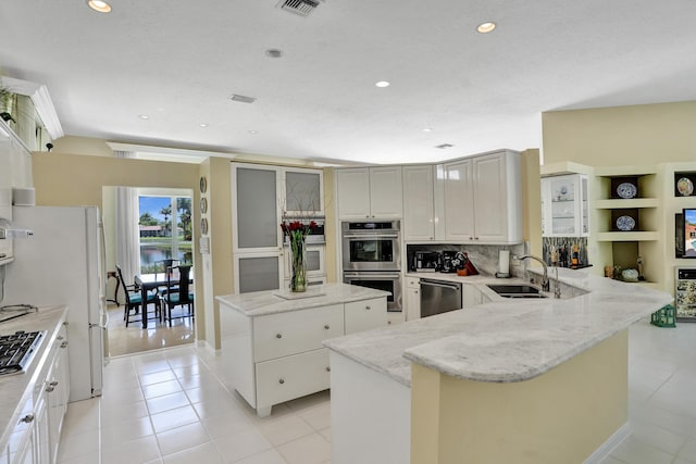 19262 Redberry Ct, Boca Raton, FL 33498 - kitchen with a sink, stainless steel appliances, light tile patterned floors, a peninsula, and a kitchen island