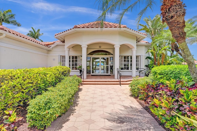 19262 Redberry Ct, Boca Raton, FL 33498 - doorway to property with stucco siding, a porch, a tiled roof, and french doors