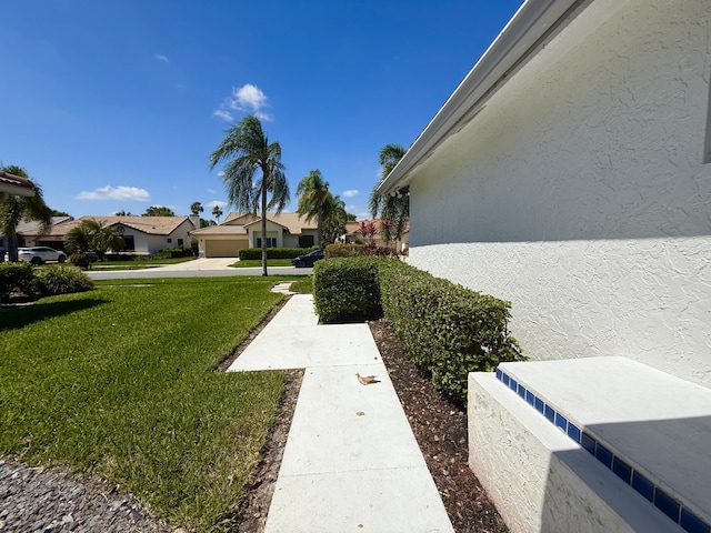 view of green lawn featuring a residential view