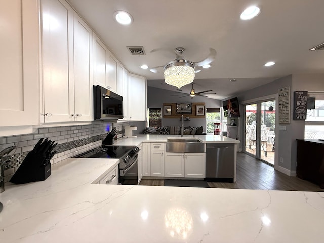 kitchen with stainless steel appliances, a sink, a ceiling fan, a peninsula, and decorative backsplash