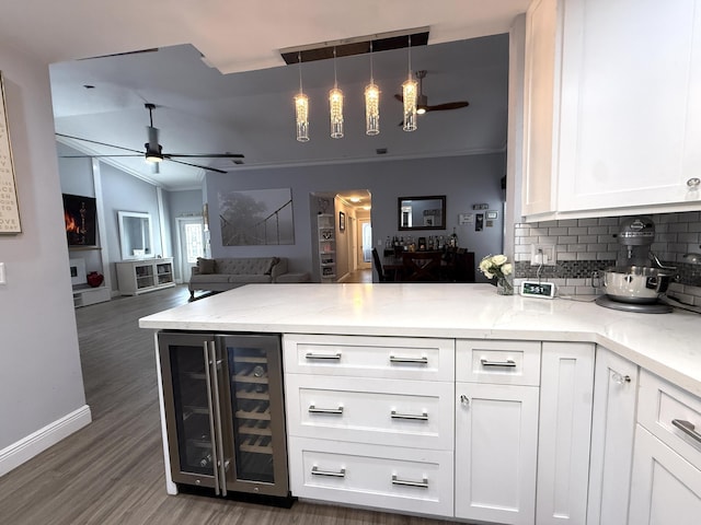 kitchen featuring ceiling fan, beverage cooler, a peninsula, tasteful backsplash, and crown molding