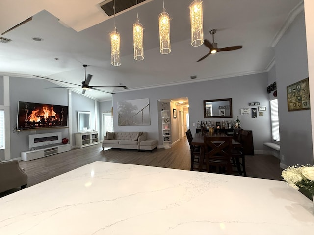 living room featuring a ceiling fan, crown molding, healthy amount of natural light, wood finished floors, and lofted ceiling