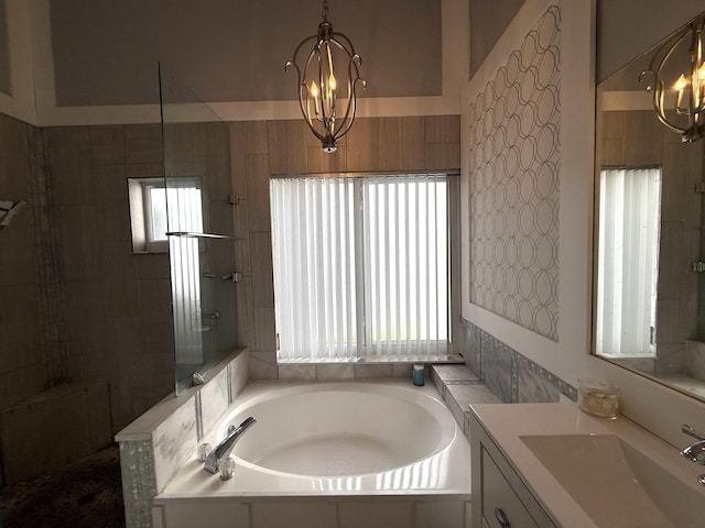 full bath featuring a chandelier, walk in shower, a garden tub, and vanity