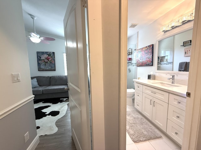 full bath featuring vanity, toilet, a ceiling fan, and connected bathroom