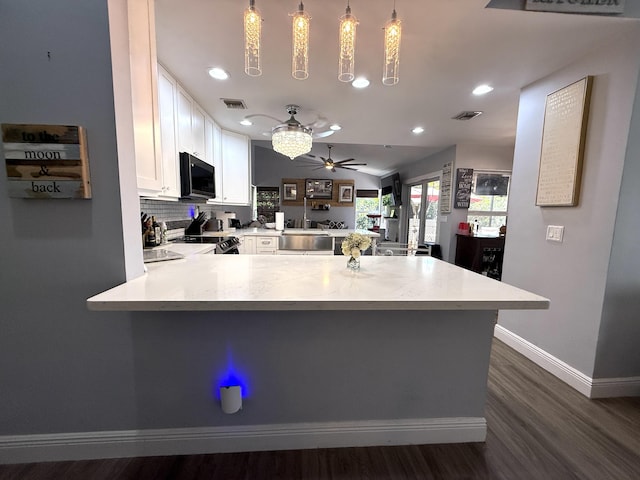 kitchen with a peninsula, range with electric stovetop, ceiling fan, dark wood-type flooring, and white cabinets