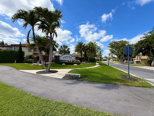 view of asphalt street with traffic signs, sidewalks, and a residential view