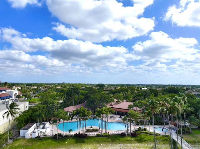view of swimming pool with view of wooded area