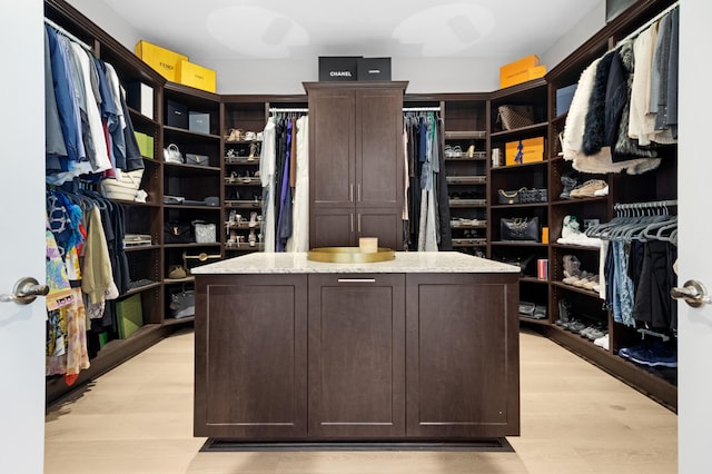 walk in closet with light wood-style floors