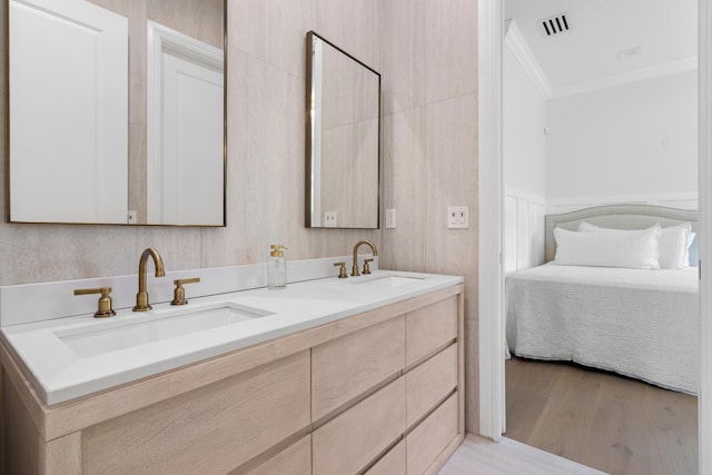 full bathroom with crown molding, wood finished floors, double vanity, and connected bathroom