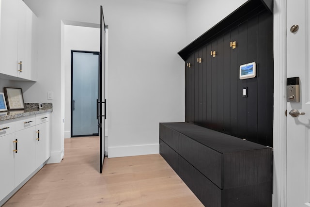 mudroom featuring light wood-style floors and baseboards
