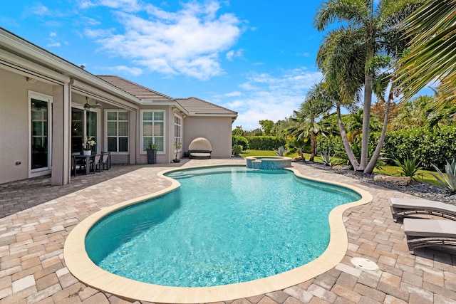 view of swimming pool featuring a patio, a pool with connected hot tub, and ceiling fan