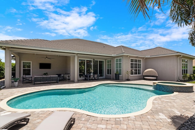 view of swimming pool featuring a patio area, a ceiling fan, a pool with connected hot tub, and an outdoor living space