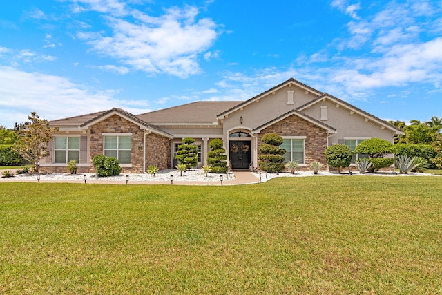 view of front of home featuring a front lawn, stone siding, and stucco siding