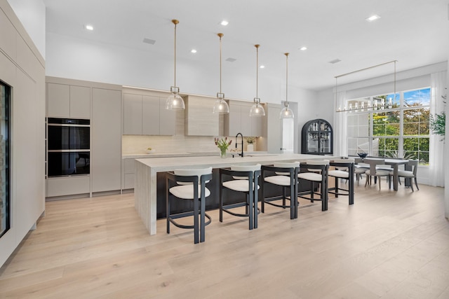 5351 N Sterling Ranch Cir, Davie, FL 33314 - kitchen featuring a large island with sink, light countertops, modern cabinets, a kitchen breakfast bar, and recessed lighting