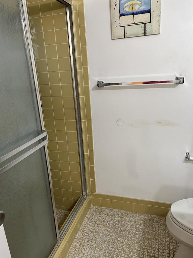 bathroom featuring a stall shower and toilet