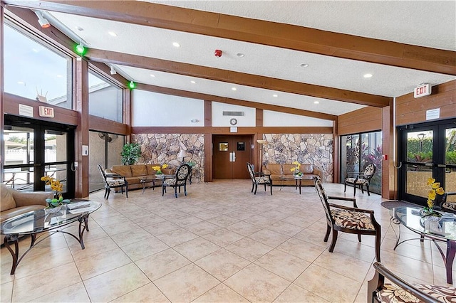 building lobby featuring beam ceiling and high vaulted ceiling