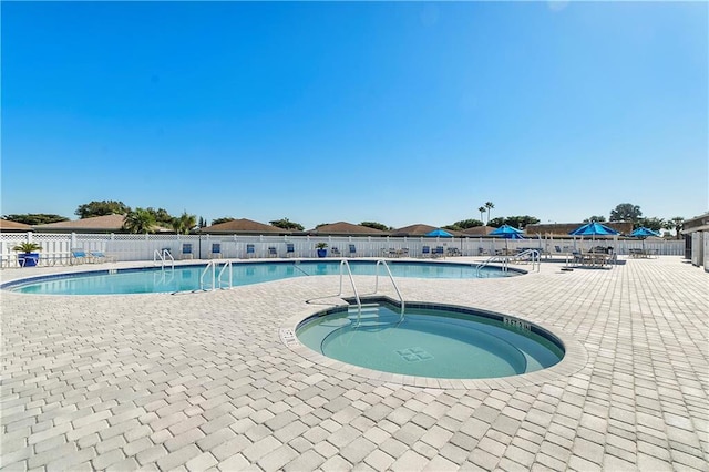 community pool featuring fence, a patio, and a community hot tub