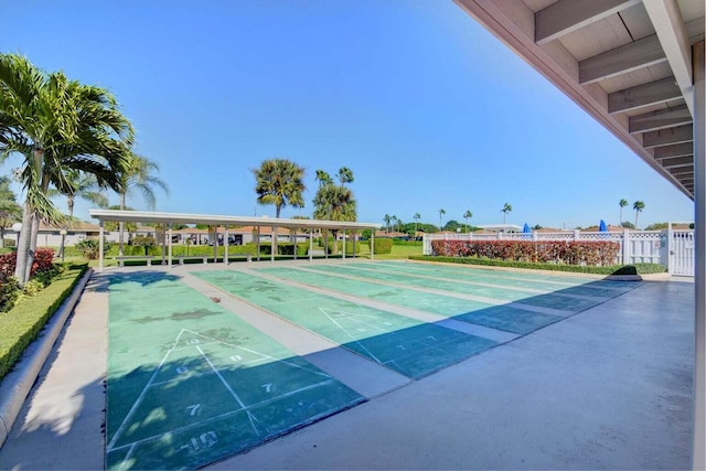 view of home's community with fence and shuffleboard