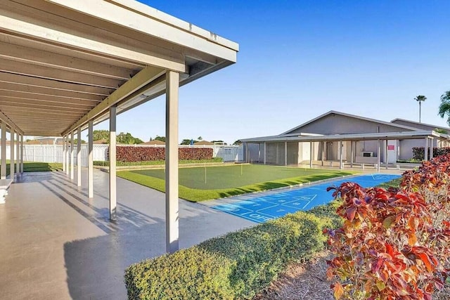 view of patio featuring a putting green, shuffleboard, and fence