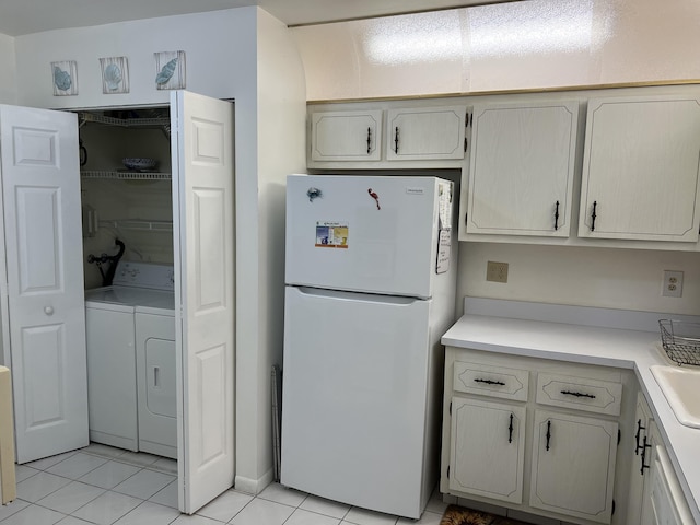 kitchen with freestanding refrigerator, washer and dryer, light tile patterned floors, and light countertops