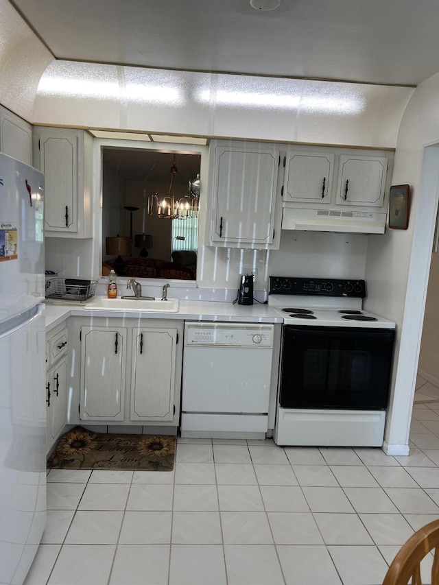 kitchen featuring white appliances, a sink, under cabinet range hood, and light countertops