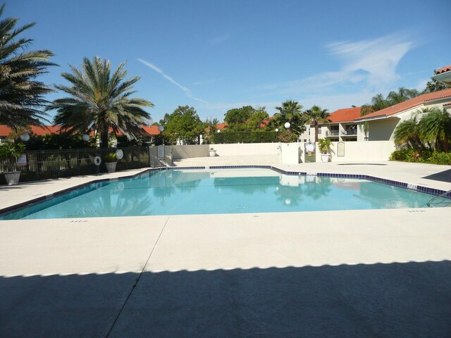 community pool featuring fence and a patio area