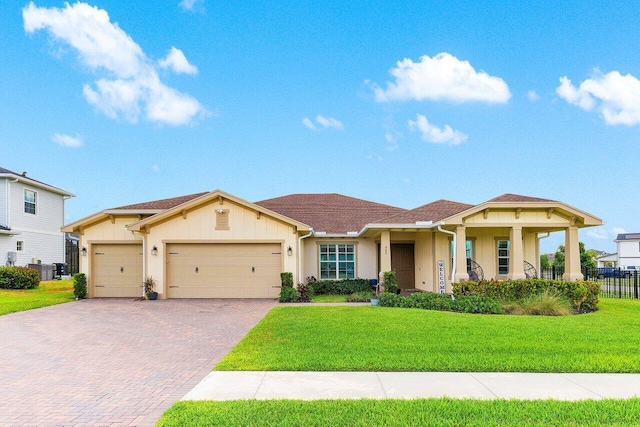 962 Castaway Ct, Loxahatchee, FL 33470 - view of front of property with an attached garage, decorative driveway, board and batten siding, and central AC