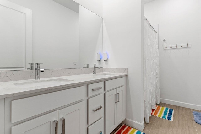 962 Castaway Ct, Loxahatchee, FL 33470 - full bathroom featuring wood finished floors, double vanity, and baseboards