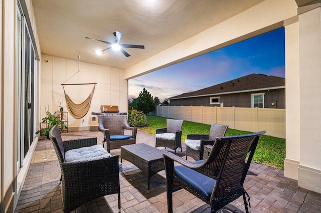 962 Castaway Ct, Loxahatchee, FL 33470 - patio terrace at dusk featuring fence, ceiling fan, and outdoor lounge area