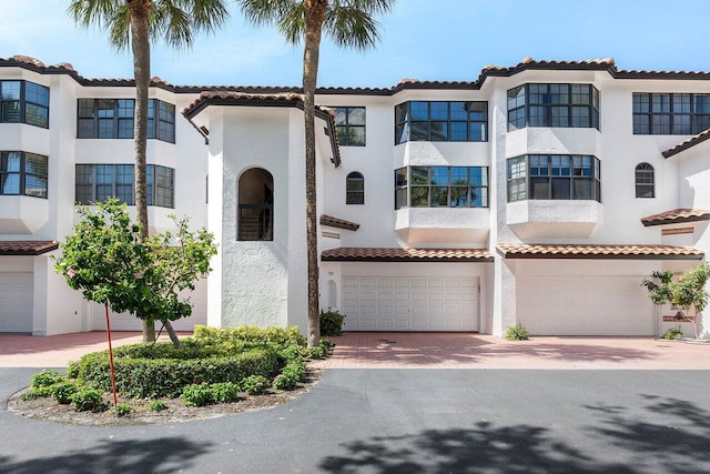 4401 N Ocean Blvd Unit 12, Boca Raton, FL 33431 - view of front of property with stucco siding, a garage, decorative driveway, and a tile roof