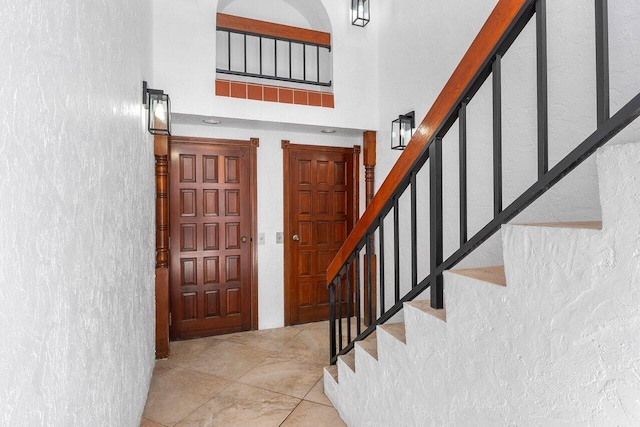 4401 N Ocean Blvd Unit 12, Boca Raton, FL 33431 - entrance foyer with a towering ceiling, stairway, and a textured wall