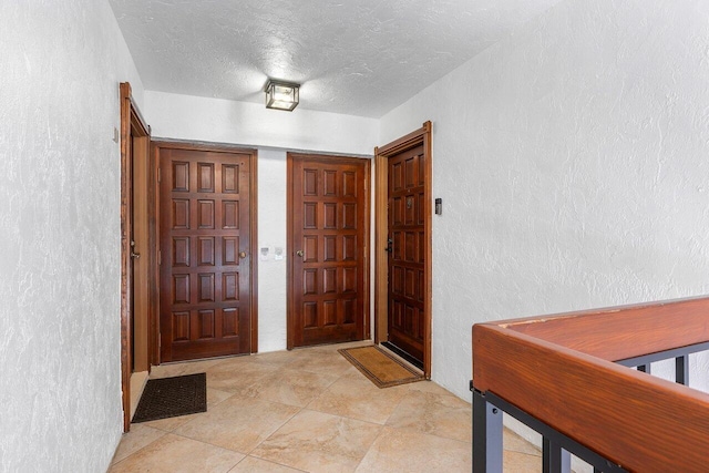 4401 N Ocean Blvd Unit 12, Boca Raton, FL 33431 - foyer entrance with a textured wall, a textured ceiling, and light tile patterned floors