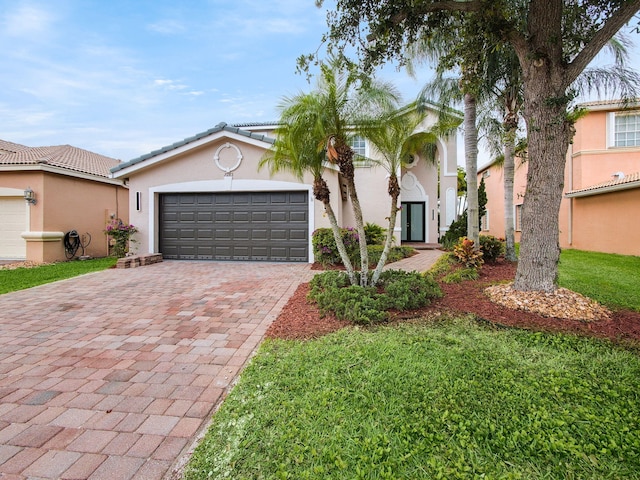 7285 Via Luria, Lake Worth, FL 33467 - view of front of house with an attached garage, a tiled roof, stucco siding, a front yard, and driveway