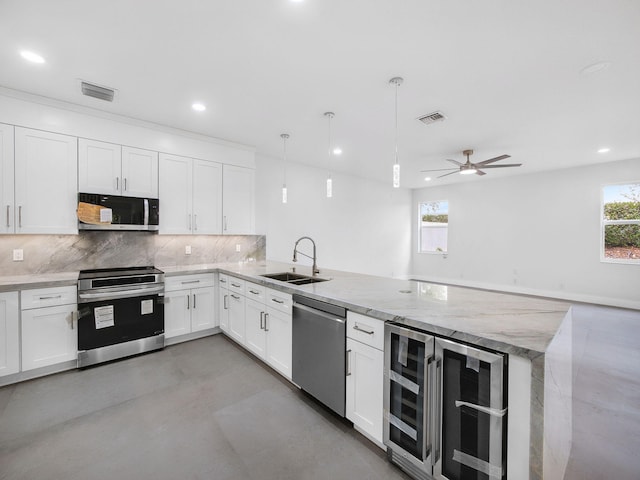 7285 Via Luria, Lake Worth, FL 33467 - kitchen with a sink, a peninsula, stainless steel appliances, visible vents, and beverage cooler