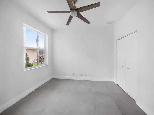 7285 Via Luria, Lake Worth, FL 33467 - unfurnished bedroom with baseboards, finished concrete flooring, a closet, and ceiling fan