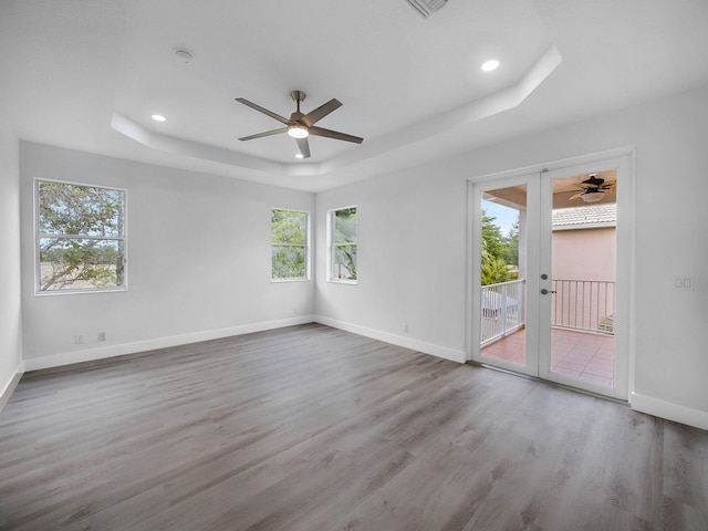 7285 Via Luria, Lake Worth, FL 33467 - spare room featuring a tray ceiling, a ceiling fan, and a healthy amount of sunlight