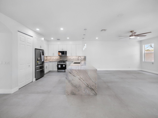 7285 Via Luria, Lake Worth, FL 33467 - kitchen with a sink, white cabinets, appliances with stainless steel finishes, decorative backsplash, and light stone counters