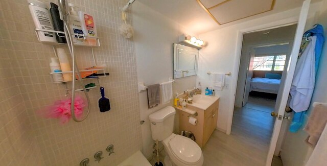 full bath featuring vanity, toilet, wood finished floors, and connected bathroom