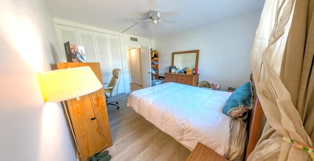 bedroom featuring wood finished floors, a closet, and ceiling fan