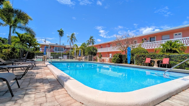 community pool featuring fence and a patio area