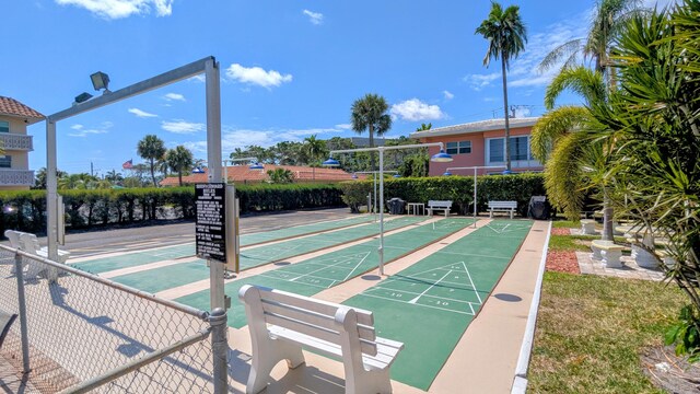 surrounding community with fence and shuffleboard