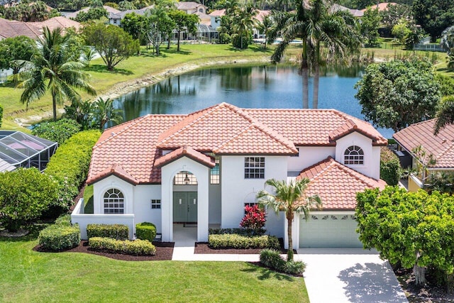 mediterranean / spanish home featuring a garage, a tiled roof, a front yard, and driveway